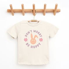 Looking for a cute tee for your kids? We have the perfect Don't Worry Be Hoppy Bunny graphic tee addition to their closet! Also available in toddler tees. Playful Cartoon Print T-shirt For Spring, Playful Spring T-shirt With Text Print, Playful Screen Print Tops For Spring, Playful Spring Screen Print Tops, Playful Slogan T-shirt For Spring, Playful Spring T-shirt With Funny Print, Cute Pre-shrunk T-shirt For Spring, Cute Pre-shrunk Spring T-shirt, Playful Spring Top With Text Print