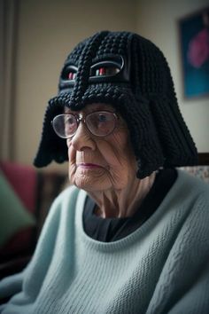 an old woman wearing a knitted hat with two eyes and a star wars helmet on her head