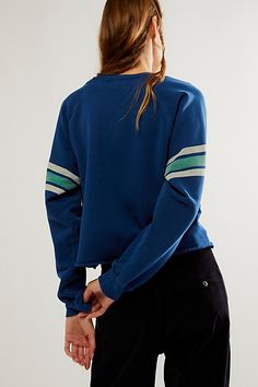 Add the perfect touch of retro-inspired style to any look with this timeless crewneck sweatshirt featuring varsity number and stripe detail at sleeves for added dimension. * Slouchy fit * Scoop neckline * Light distressing throughout * Raw bottom hemline | Retro Sport Sweatshirt by Original Retro Brand at Free People in Blue, Size: XS Sporty Sweatshirt With Raglan Sleeve And Ribbed Cuffs, Trendy Campus Top With Ribbed Cuffs, Sporty Tops With Ribbed Cuffs And Raglan Sleeves, Casual Crew Neck Sweatshirt With Striped Cuffs, Sporty French Terry Tops With Ribbed Cuffs, Sporty Tops With Striped Cuffs For Fall, Trendy French Terry Tops For College, Fall College Sweatshirt With Contrast Stripes, Blue Sporty Raglan Sleeve Top