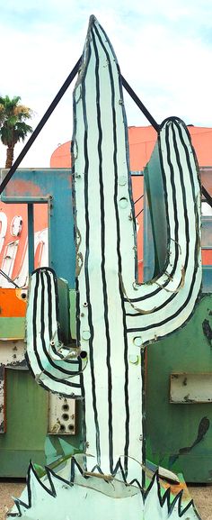 a large metal cactus sitting in front of a building