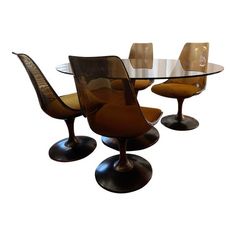 an oval glass dining table with four tulip chairs