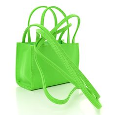 This is an authentic TELFAR Vegan Leather Small Shopping Bag in Highlighter Green. This is a tote crafted of synthetic leather in green with the iconic raised Telfar logo at the front. The shoulder bag has short top handles, and two long shoulder straps. The top secures with a magnet snap and opens to a matching green fabric lined interior. Telfar Logo, Green Highlights, Orange Bag, Green Fabric, Synthetic Leather, Highlighter, Short Tops, Shoulder Straps, Vegan Leather