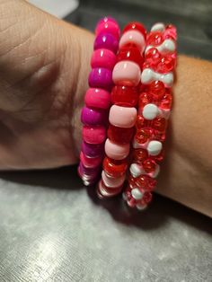 This Valentine's Day inspired beaded bracelet set is fun for everyone! Great for parties, concerts and more! Includes the colors: red, pink, majenta and white. Pink Stackable Beaded Bracelets For Party, Trendy Pink Stretch Bracelet For Party, Valentine's Day Beaded Stretch Bracelet With Round Beads, Valentine's Day Stretch Bracelet With Round Beads, Red Beaded Stretch Bracelet For Valentine's Day, Adjustable Beaded Bracelet For Valentine's Day, Adjustable Beaded Stretch Bracelet For Valentine's Day, Trendy Colorful Bead Bracelets For Valentine's Day, Trendy Colorful Beads Bracelets For Valentine's Day