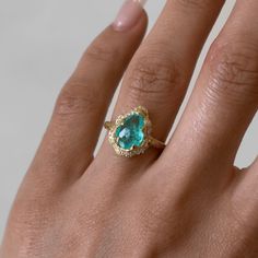 18K Baby Queen Water Drop Paraiba Ring with Full Pavé Diamond Halo | Ready to Ship Yellow Gold 5.5  by Logan Hollowell Jewelry Yellow Gold Diamond Halo Ring With Gemstone, 14k Yellow Gold Pear-shaped Emerald Ring, Pear-shaped Emerald Ring In 14k Yellow Gold, Luxury Gold Halo Ring With Gemstone, Luxury Yellow Gold Halo Ring With Gemstone, Gia Certified Gold Halo Ring Fine Jewelry, Unique Gemstone Cluster Ring In Yellow Gold, Yellow Gold Pear-shaped Emerald Ring, Exquisite Yellow Gold Cluster Ring With Gemstone