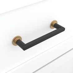 a black handle on a white cabinet with brass handles and knobs in the drawer