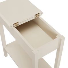 a white table with an open drawer on it's side and two gold handles