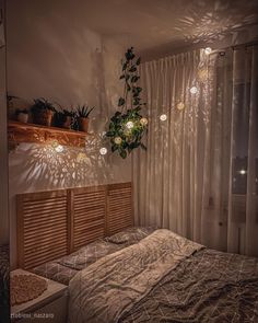 a bed sitting in a bedroom next to a window with curtains on the windowsill