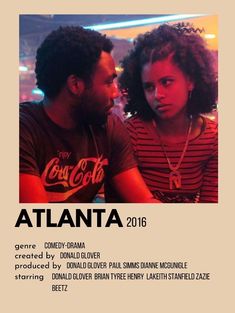 a man and woman sitting next to each other in front of a sign that says atlanta