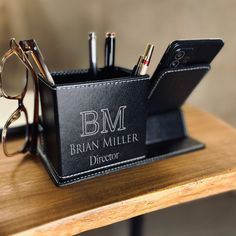 a black leather pen holder with glasses and pens