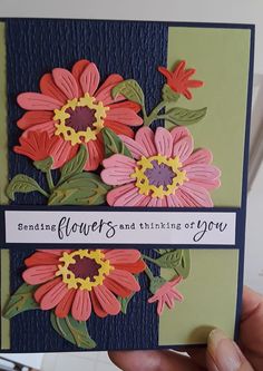 a hand holding up a card with flowers on it and the words sending flowers and thinking of you