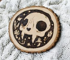 a wooden button with a skull and stars in the center on a white knit background