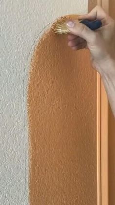 a person is painting the wall with a brush