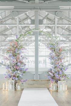 two tall vases filled with flowers sitting on top of a table