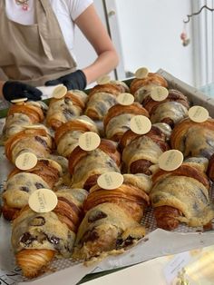 there are many croissants on the table and one person is standing behind them