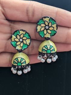 These Elegant Hand painted enamel jhumka earrings are a fusion of classic charm and modern flair, making them an exceptional accessory. They're not just jewelry; they're a statement piece that exudes sophistication and style, perfect for enhancing any outfit with a touch of elegance. Green Enamel Earrings With Artistic Design, Dual-tone Green Earrings As Gift, Multicolor Meenakari Danglers, Fusion Green Meenakari Danglers, Fusion Style Green Meenakari Danglers, Green Fusion Style Jhumkas, Hand Painted Jewelry For Festivals, Traditional Hand Painted Enamel Earrings, Traditional Enamel Hand Painted Earrings