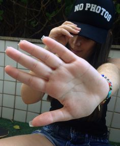 a woman is holding her hand out in front of the camera with no photos on it