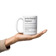 a person's hand holding a coffee mug with the words geotechical engineer on it