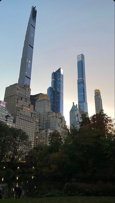 the city skyline is lit up at night, with skyscrapers in the foreground