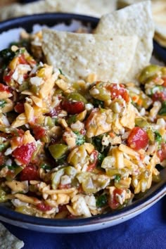 a bowl filled with salsa and tortilla chips on top of a blue cloth