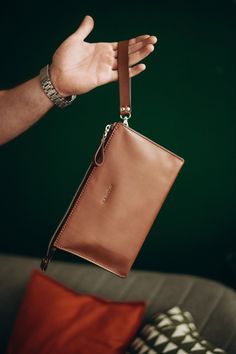 The Men's Leather Clutch is a meticulously handcrafted accessory that combines style, craftsmanship, and functionality. Made from high-quality leather, this compact yet spacious clutch is designed to meet the needs of the modern man on the go. With its attention to detail and fine craftsmanship, this leather handbag exudes a sense of luxury and sophistication. The supple and durable leather ensures longevity, making it a reliable companion for years to come. Its sleek and minimalist design adds Men Clutch Bag, Mens Leather Wallet, Designer Clutch Bags, Leather Duffle Bag, Leather Passport Cover, Handbag Leather, Handcrafted Accessories, Mens Leather Bag, Designer Handbag