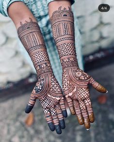 a person with henna tattoos on their arms and hands, both showing intricate designs