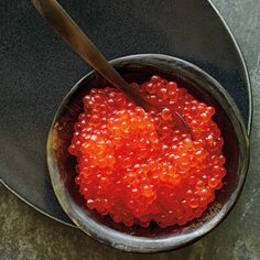 a bowl filled with red beads and a spoon