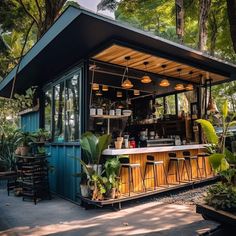 an outdoor bar with lots of plants and potted plants on the outside, surrounded by trees