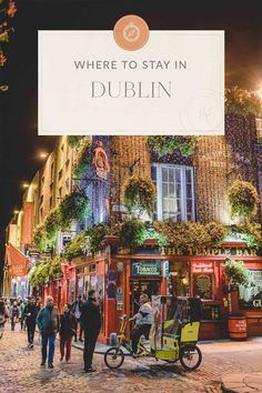 people walking down the street in dublin at night with a sign that says where to stay in dublin