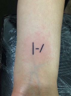 a person with a small tattoo on their wrist that reads 1 - 2 / 4