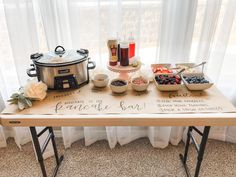 a wooden table topped with bowls of food next to a pot and pan filled with condiments