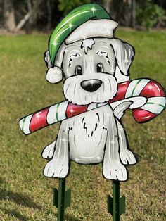 a christmas yard decoration with a dog holding a candy cane