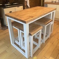 a kitchen island with three stools in it