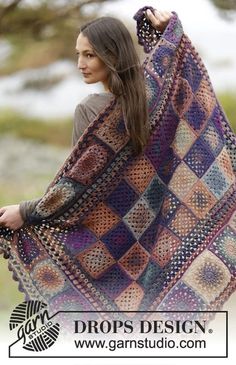 a woman is holding up a crocheted blanket in front of her face and the words drops design on it