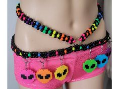 This kandi belt is made with neon pony beads and alien perlers. Glows under blacklight! Includes one kandi belt. Harness sold separately. One size fits most. This item ties in the back & around neck for easy adjusting. This Item is premade and is ready to ship! Perfect for any event! You will get lots of compliments in this unique wearable art! Stand out at your next event! Edm festival  Raves Party  Rave outfit  Festival outfit Pride Mardi gras Rave gift  Rave birthday Glow party Hypercore Outfits, Neon Rave Outfits Ideas, Edc Kandi Ideas, Kandi Outfits, Kandi Leg Garter, Kandi Rave, Kandi Clothing, Kandi Harness Tutorial, Kandi Belt