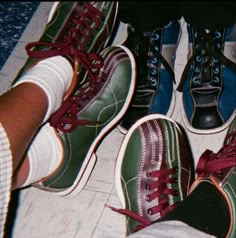 four pairs of shoes with red and green laces on them are standing in a circle