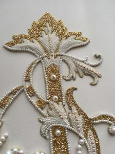 an embroidered design with gold and white beads