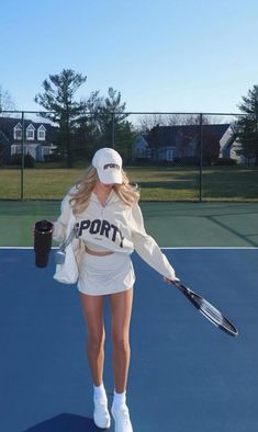 a woman holding a tennis racquet on top of a tennis court