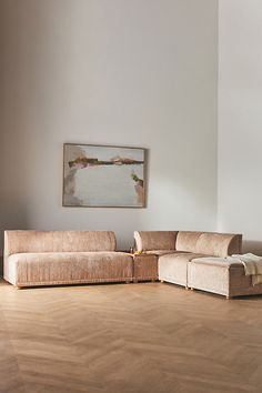 a living room with wood flooring and a painting hanging on the wall above it