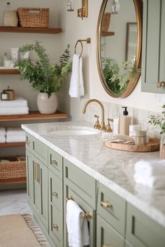 a bathroom with green cabinets and marble counter tops