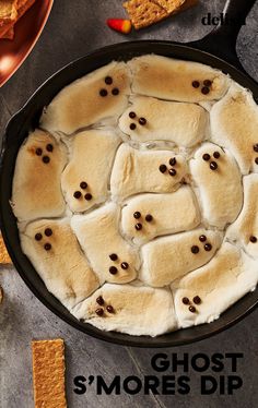 a cast iron skillet filled with marshmallows and topped with ghost s'mores