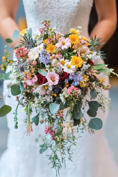 a bridal holding a bouquet of flowers and greenery