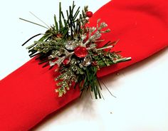 a close up of a red tie with flowers and leaves on the end, sitting on a white surface