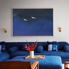 a living room filled with furniture and a painting on the wall