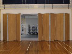 an empty gym with wooden doors and hard wood flooring