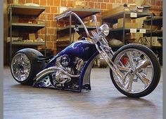 a shiny blue motorcycle parked in a garage next to shelves filled with boxes and other items