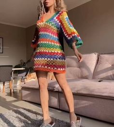 a woman in a multicolored crochet sweater dress