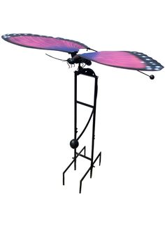 a pink and purple butterfly on top of a black metal stand with an umbrella attached to it