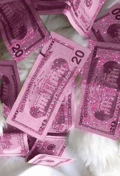 there is a dog that is laying down on the bed covered in pink money bills