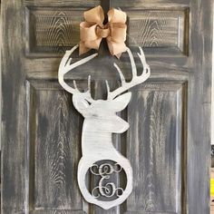 a wooden deer head with a bow on it's antlers is mounted to the front door