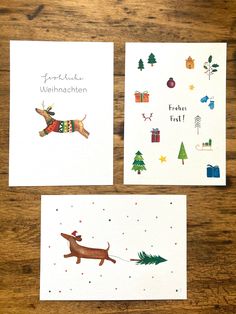 three christmas cards on top of a wooden table next to each other, one with a dachshund